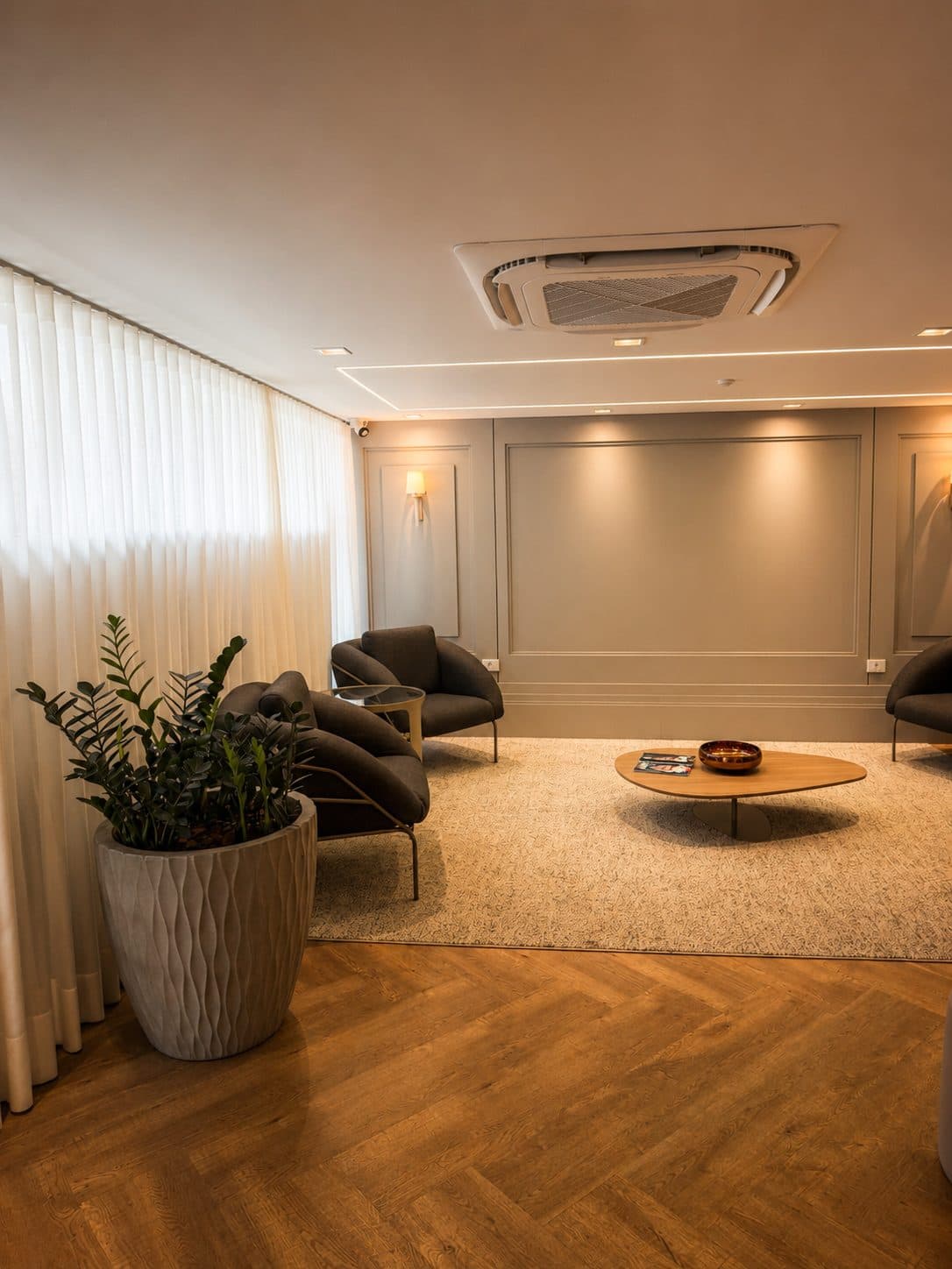 MYJOB Afonso Pena: sala de estar com poltronas escuras e planta