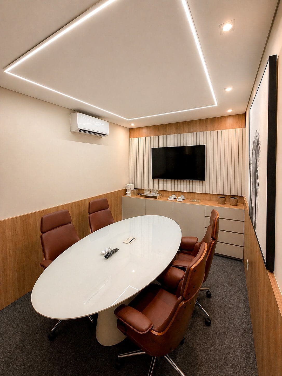 MYJOB Executive: sala de reunião com mesa oval branca, cadeiras de couro marrom, TV e aparador