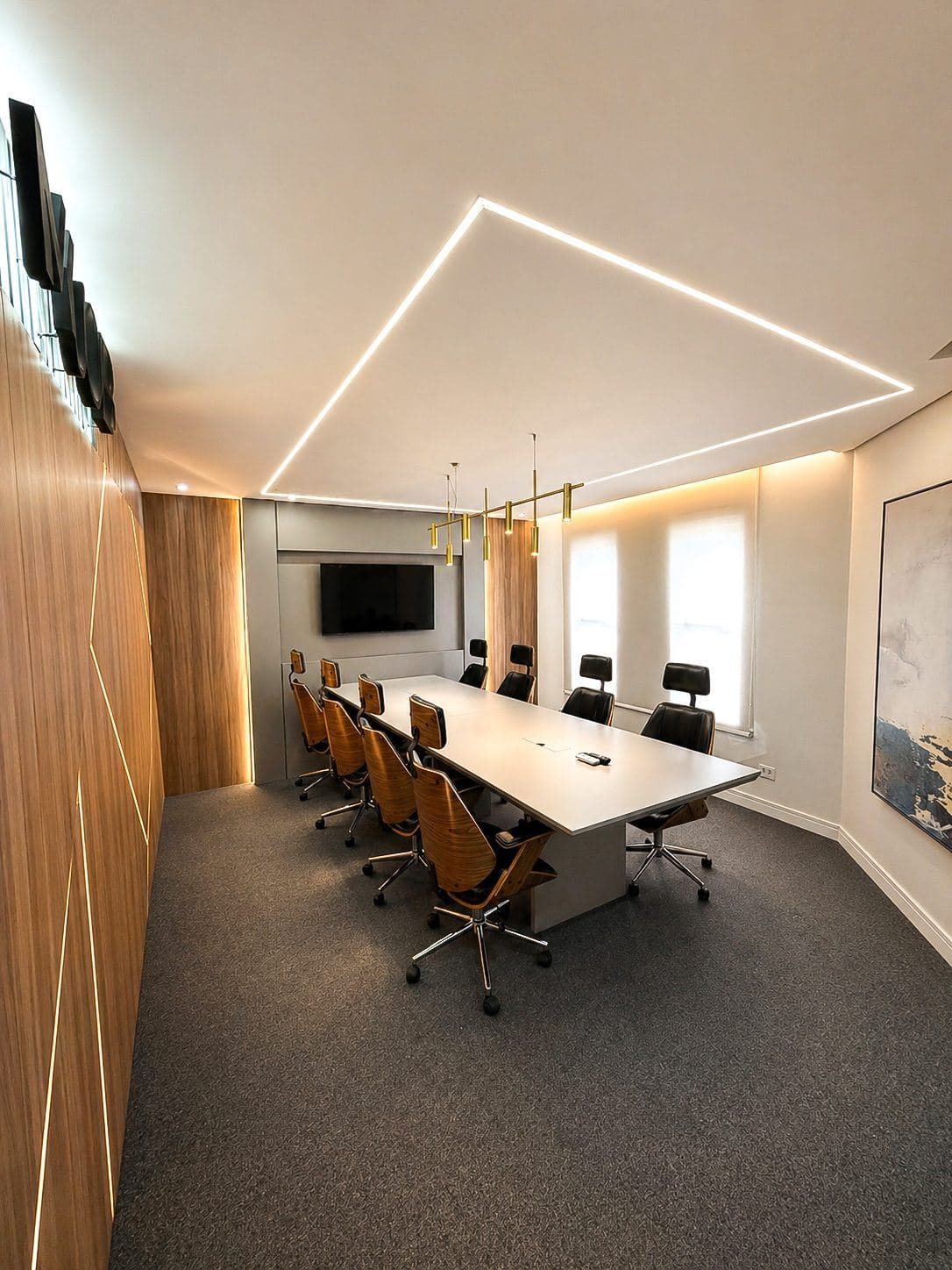 MYJOB Executive: sala de reunião com mesa retangular longa, cadeiras de madeira e couro, TV ao fundo e janelas com persiana